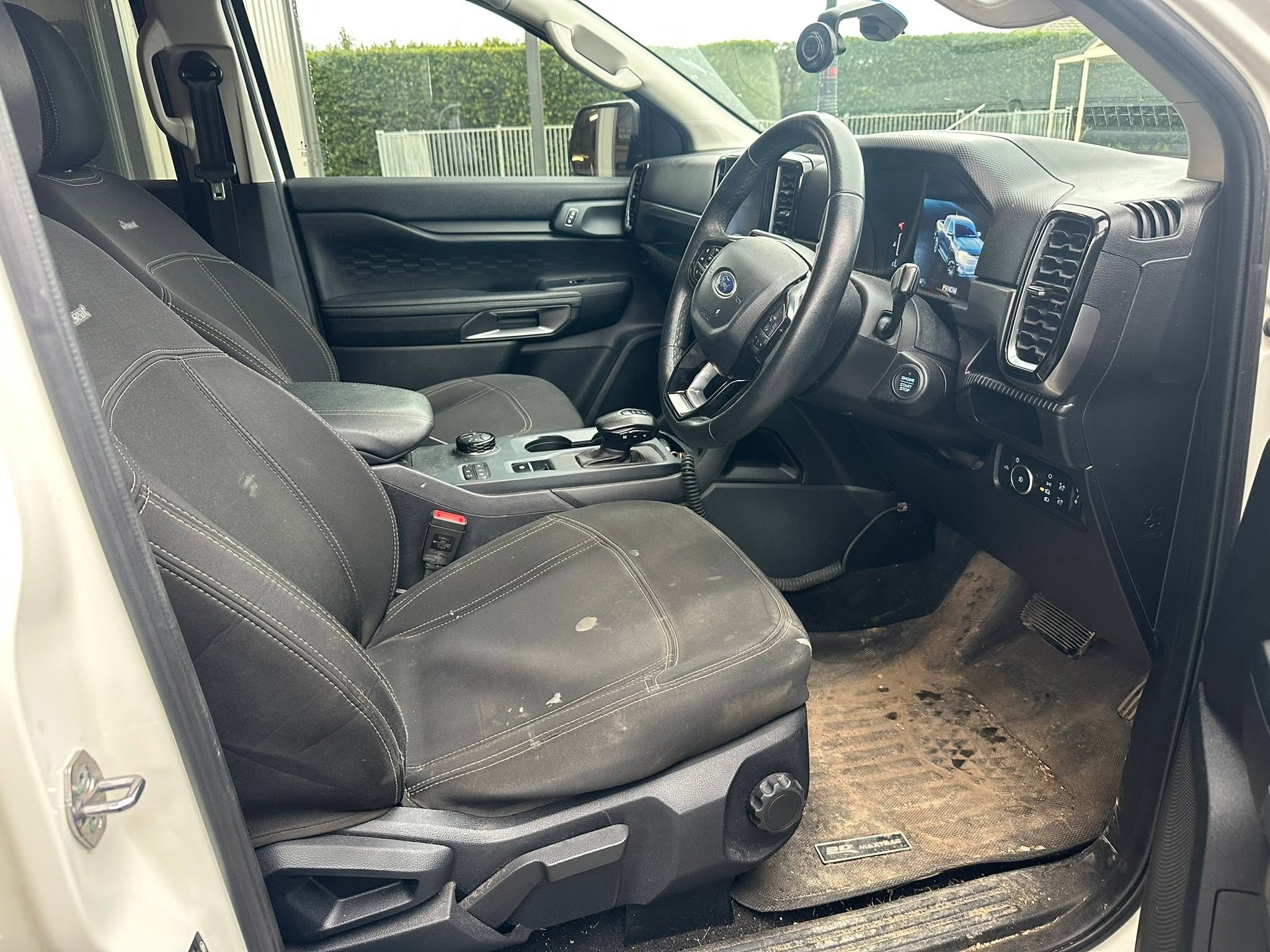 Ute interior before professional interior detailing, showing dirt and mud on floor mats